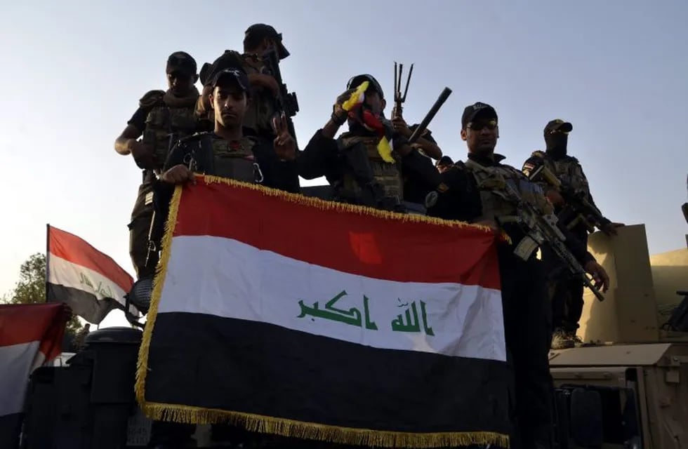 EBAG11. Mosul (Iraq).- (FILE) - Iraqi soldiers hold up the Iraqi national flag in central Mosul, northern Iraq, 10 July 2017 (reissued 09 December 2017). Iraqi Prime Minister Haidar al-Abadi on 09 December 2017 announced the remaining Iraqi region under Islamic state control, nearby the Iraqi border with Syria was now under complete control of Iraq's armed forces, putting to an end its war against the so-called Islamic State. (Siria) EFE/EPA/STR *** Local Caption *** 53640127