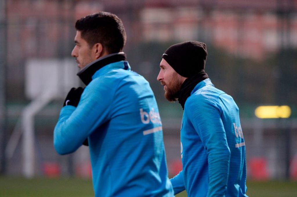 Messi, al salir al campo de juego con Luis Suárez. (AFP)