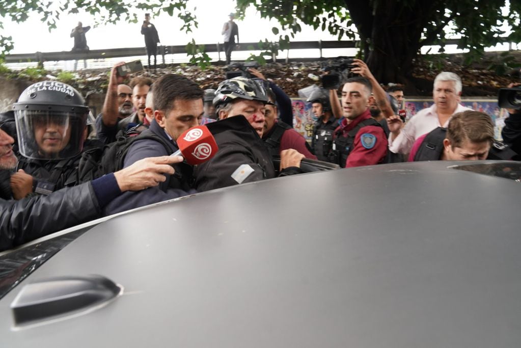 Así evacuaban a Sergio Berni tras el ataque a golpes en la protesta por el crimen del colectivero (Foto: Maxi Failla / Clarín)
