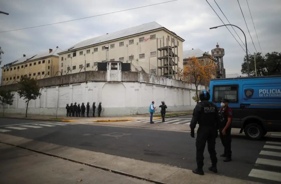 Police take position outside the Villa Devoto prison where inmates riot to protest authorities are not doing enough to prevent the spread of coronavirus inside the jail in Buenos Aires, Argentina, Friday, April 24, 2020. (AP Photo/Natacha Pisarenko)