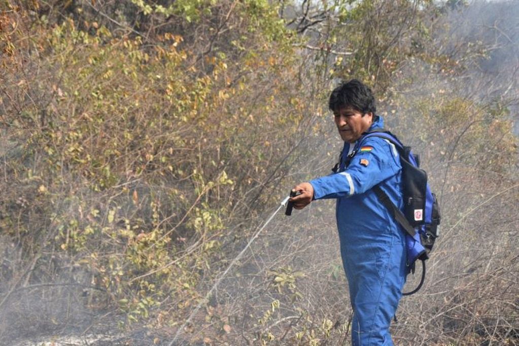 Esta foto publicada por el Ministerio de Comunicación boliviano muestra al presidente Evo Morales rociando agua en un incendio en la comunidad de Santa Rosa, cerca de Robore, en el este de Bolivia, al sur de la cuenca del Amazonas, el 28 de agosto de 2019. (Photo by HO / Ministerio de Comunicacion de Bolivia / AFP)