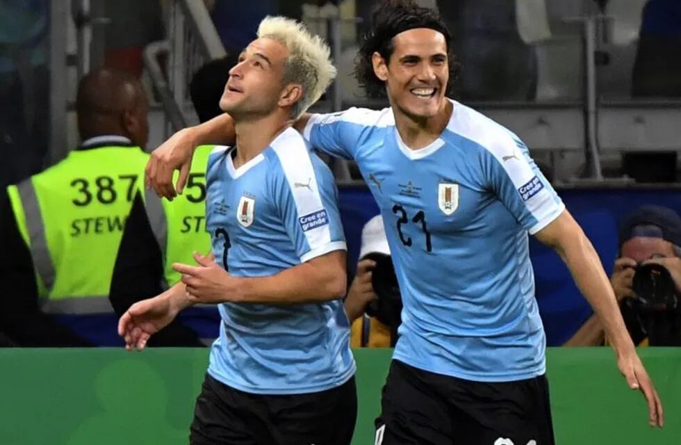 Uruguay's Nicolas Lodeiro (L) celebrates with teammate Edinson Cavani after scoring against Ecuador during their Copa America football tournament group match at the Mineirao Stadium in Belo Horizonte, Brazil, on June 16, 2019. (Photo by Luis ACOSTA / AFP)
