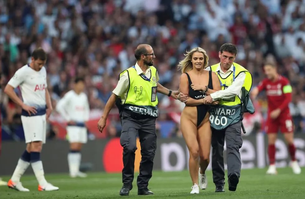 A woman that has invaded the pitch is taken away by security during the Champions League final soccer match between Tottenham Hotspur and Liverpool at the Wanda Metropolitano Stadium in Madrid, Saturday, June 1, 2019. (AP Photo/Francisco Seco)