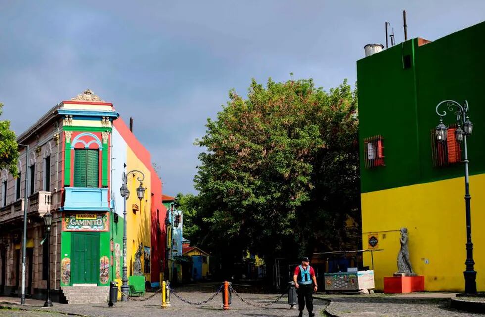 A lone police officer walks along the empty Caminito street at La Boca neighbourhood in Buenos Aires, on March 30, 2020. - Compulsory social isolation was extended until April 12 in Argentina, the government announced Sunday as 820 people infected and 20 dead were so far reported in the South American nation. (Photo by RONALDO SCHEMIDT / AFP)