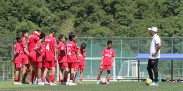 Nahuel Oyola hablando con sus pequeños dirigidos en el entrenamiento en su escuela de fútbol en China