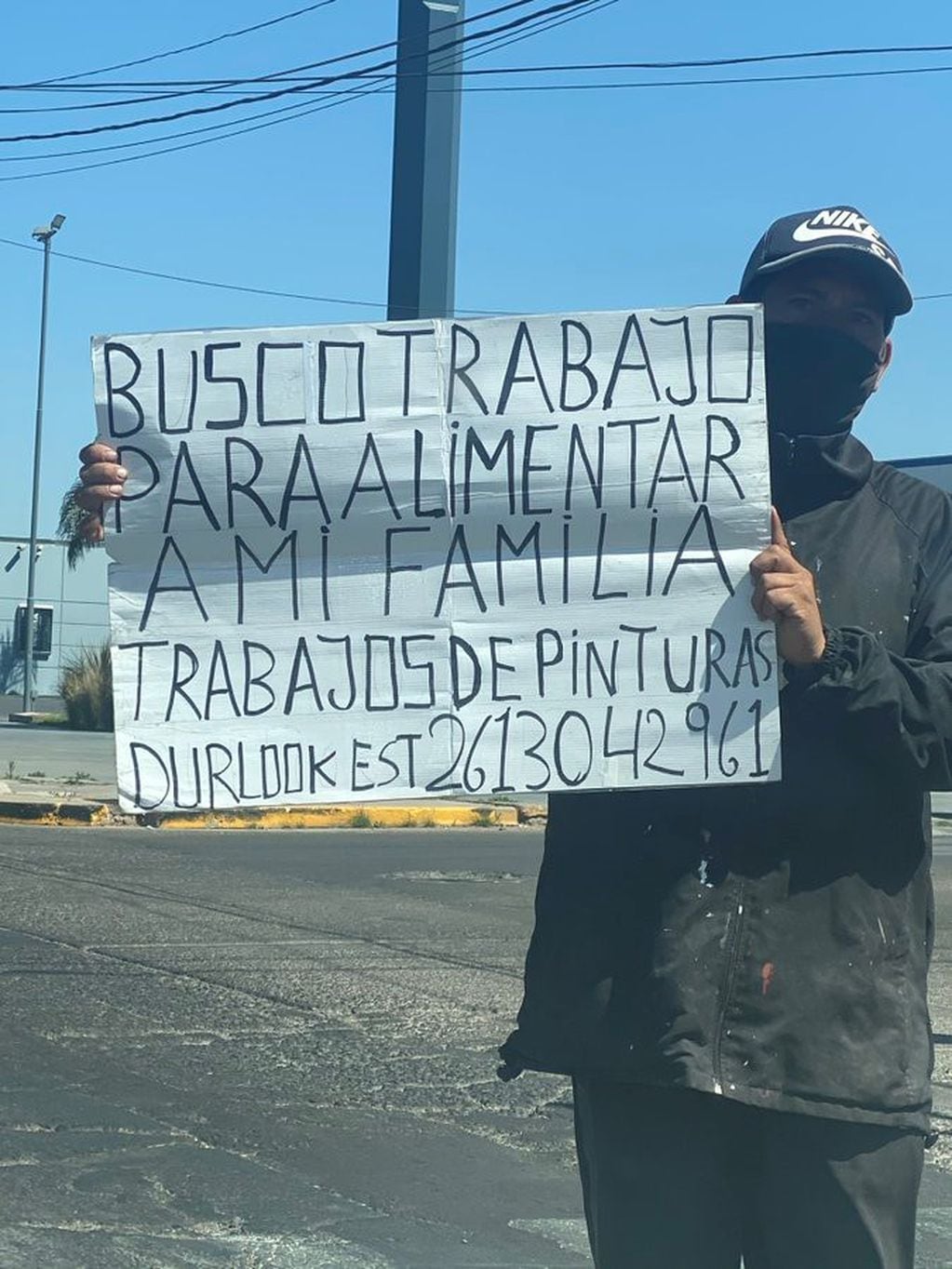 Busca trabajo con un cartel por las calles de Godoy Cruz.