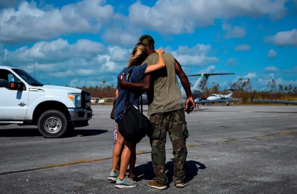 La voluntaria Dena Wood de Austin, Texas, abraza a su amigo Fritz después de que llegó con suministros de socorro al aeropuerto en Treasure Cay en la isla de Abaco, Bahamas, el 11 de septiembre de 2019, después del paso del huracán Dorian. Crédito: Andrew CABALLERO-REYNOLDS / AFP.