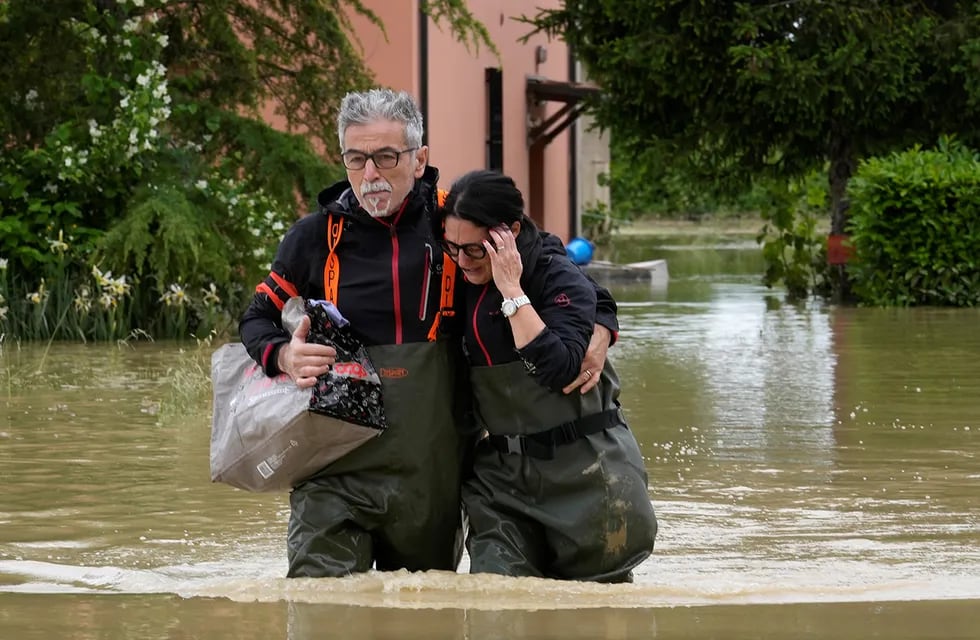 Una pareja camina en una carretera inundada de Lugo, Italia. (AP)