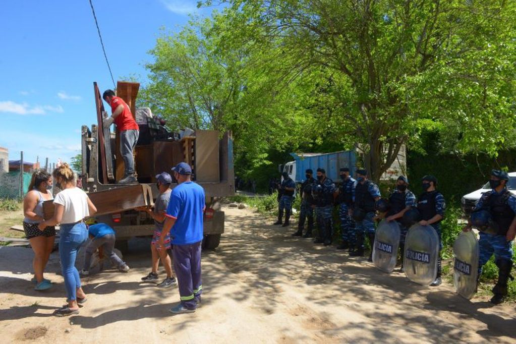 Efectivos de la Policía Bonaerense custodian el desalojo de más de 60 familias que ocupaban un terreno en Escobar. (Clarín)