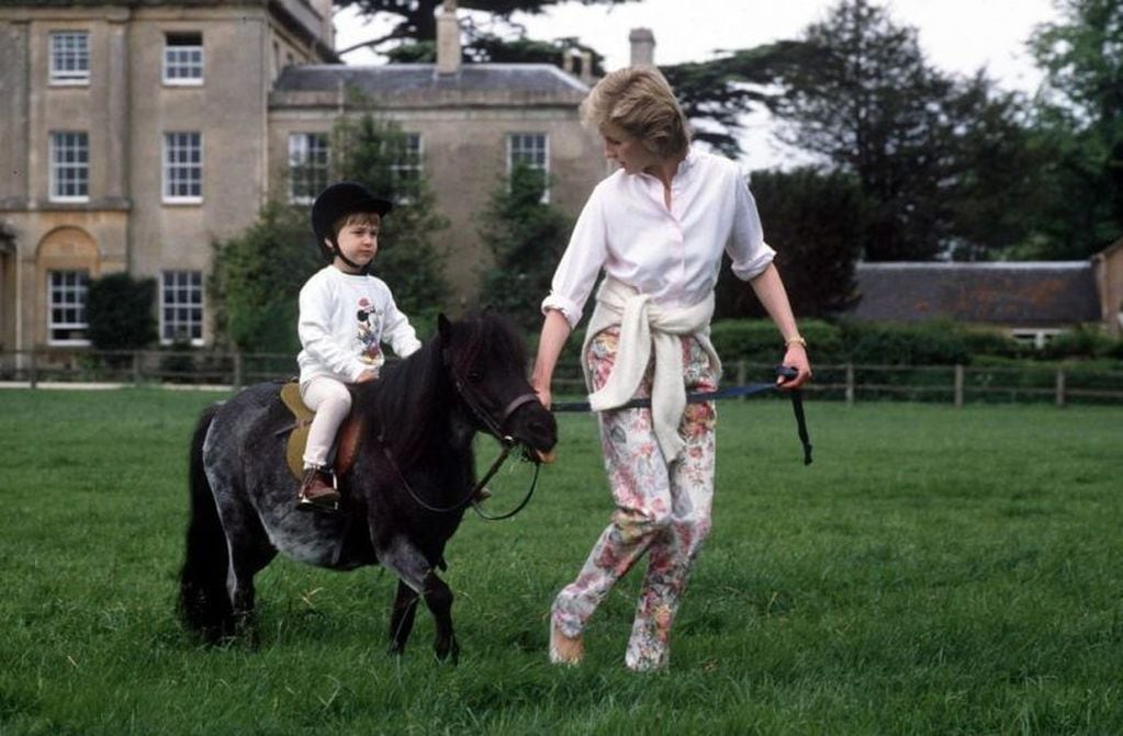 1986: Ayudando al príncipe William a montar en su pony en Highgrove.