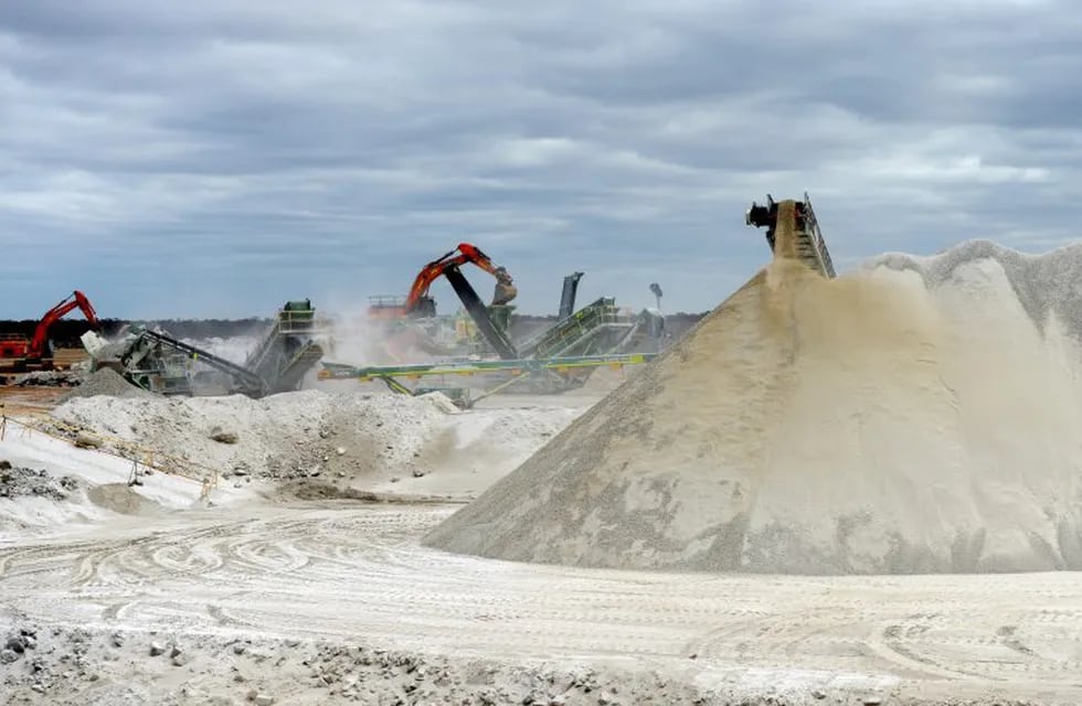 Lithium ore falls from a chute onto a stockpile as excavators operate in the background at the Bald Hill lithium mine site, co-owned by Tawana Resources Ltd. and Alliance Mineral Assets Ltd., outside of Widgiemooltha, Australia, on Monday, Aug. 6, 2018. Australia’s newest lithium exporter Tawana is in talks with potential customers over expansion of its Bald Hill mine and sees no risk of an oversupply that would send prices lower. Photographer: Carla Gottgens/Bloomberg australia  mina de litio Bald Hill copropiedad de Tawana Resources Ltd expansión de su mina instalaciones