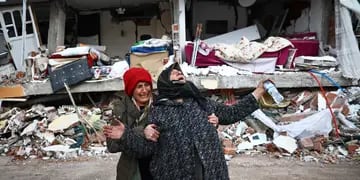Mujeres reaccionan en el lugar de un edificio derrumbado tras un gran terremoto en el distrito de Elbistan de Kahramanmaras, Turquía