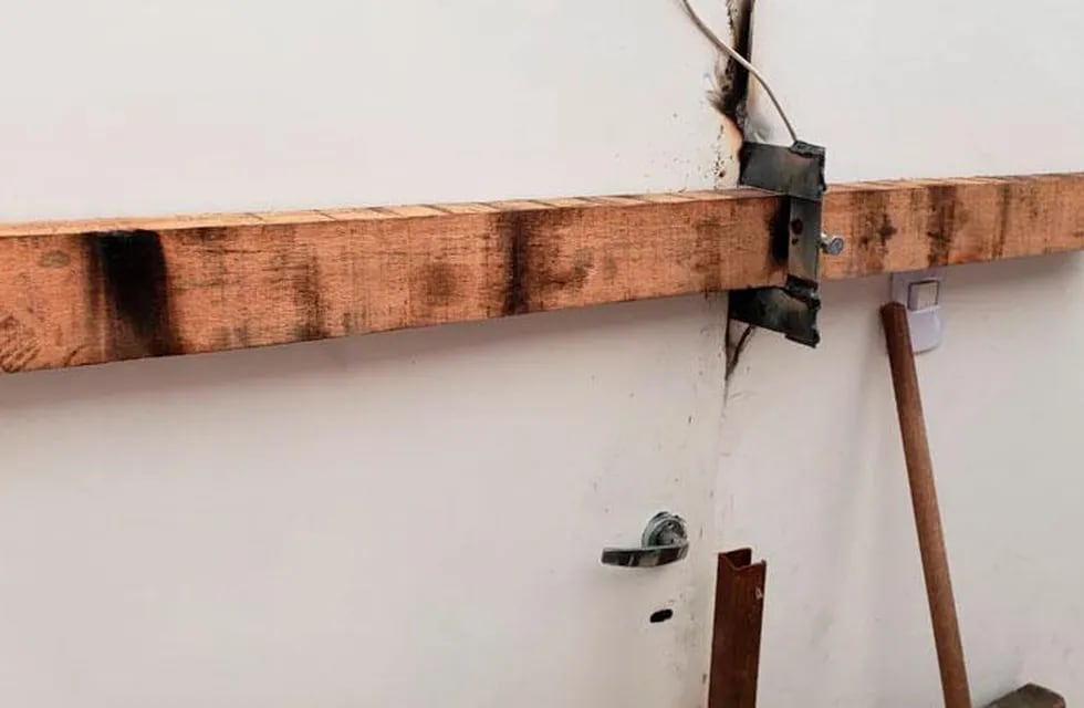 Tras el destrozo de la puerta del local, el dueño recurre a una tranca de madera para que no le sigan robando.