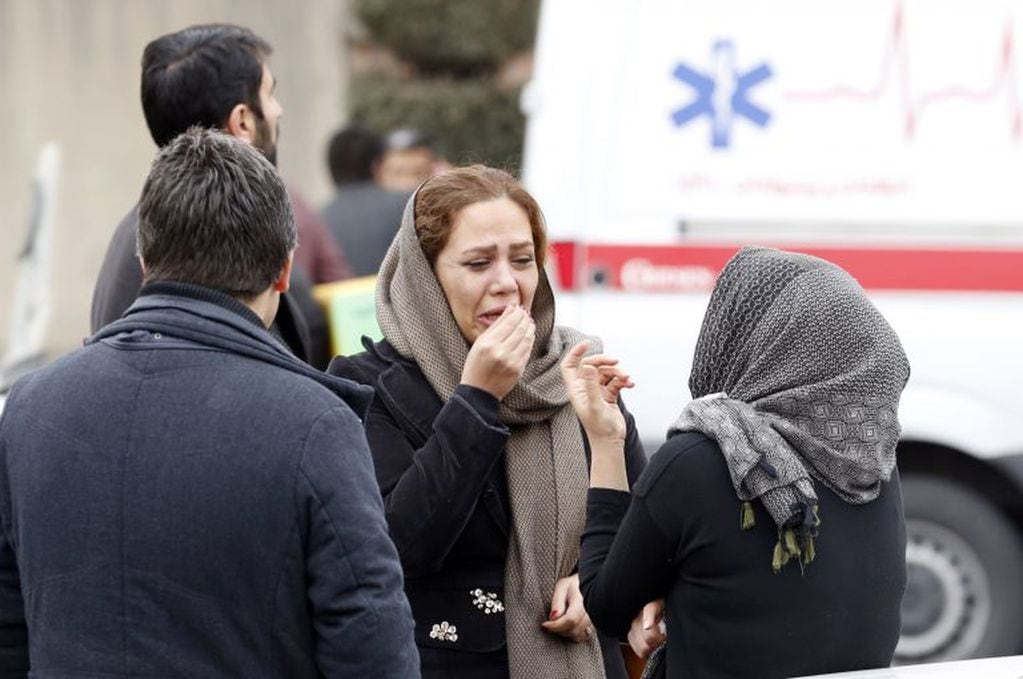 Relatives of Iranian passengers, onboard the Aseman Airlines flight EP3704, react as they gather in front of a mosque near Tehran's Mehrabad airport on February 18, 2018. 
All 66 people on board an Iranian passenger plane were feared dead after it crashed into the country's Zagros mountains, with emergency services struggling to locate the wreckage in blizzard conditions.  / AFP PHOTO / ATTA KENARE