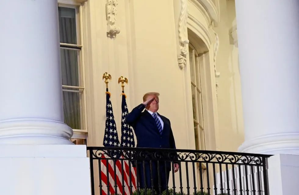 U.S. President Donald Trump salutes as he poses without a face mask on the Truman Balcony of the White House after returning from being hospitalized at Walter Reed Medical Center for coronavirus disease (COVID-19) treatment, in Washington, U.S. October 5, 2020. REUTERS/Erin Scott