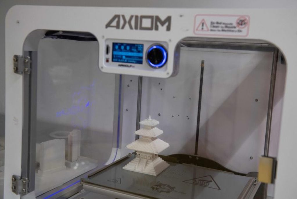 A building model sits inside a 3D-printer after it was completed at ABC Imaging in Washington, DC, on August 1, 2018.
A US judge on July 31, 2018 temporarily blocked the online publication of blueprints for 3D-printed firearms, in a last-ditch effort to stop a settlement President Donald Trump's administration had reached with the company releasing the digital documents.Eight states and the District of Columbia, which houses the capital Washington, had filed a lawsuit against the federal government, calling its settlement with Texas-based Defense Distributed "arbitrary and capricious."
 / AFP PHOTO / SAUL LOEB eeuu  venta de impresoras 3D impresion 3d