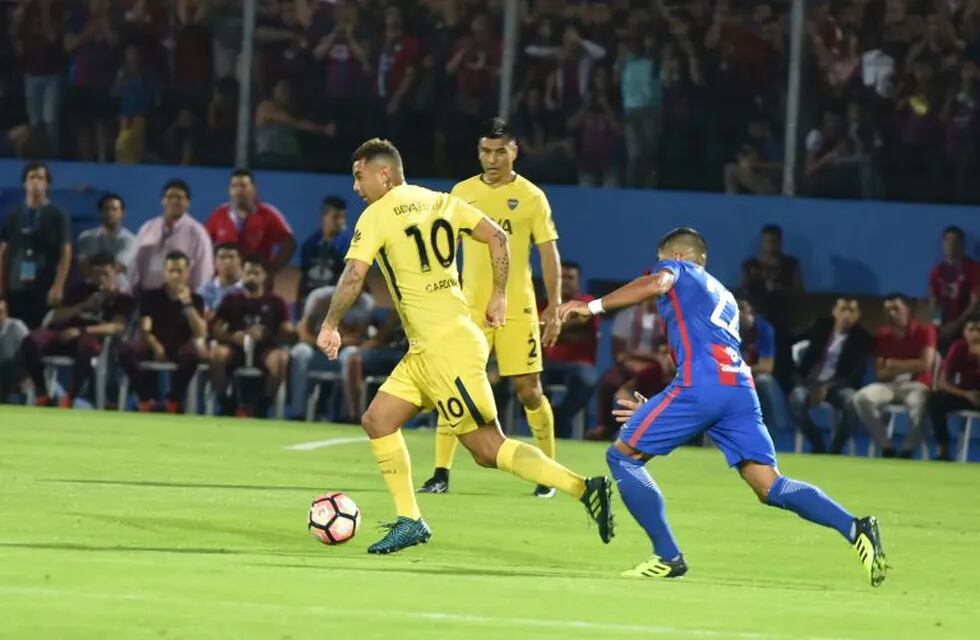 Juan Aguilar (R) of Paraguay’s Cerro Porteno vies for the ball with Edwin Cardona of Argentina's Boca Juniors during a friendly match for the inauguration of the new stadium of the Cerro Porteno club in Asuncion, Paraguay, on August 19, 2017. / AFP PHOTO / NORBERTO DUARTE