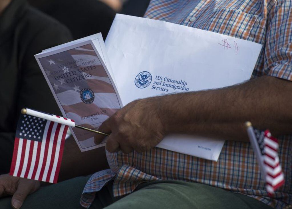Un nuevo ciudadano estadounidense sostiene los papeles antes de su ceremonia de naturalización, en Alexandria, Virginia (ANDREW CABALLERO-REYNOLDS / AFP)