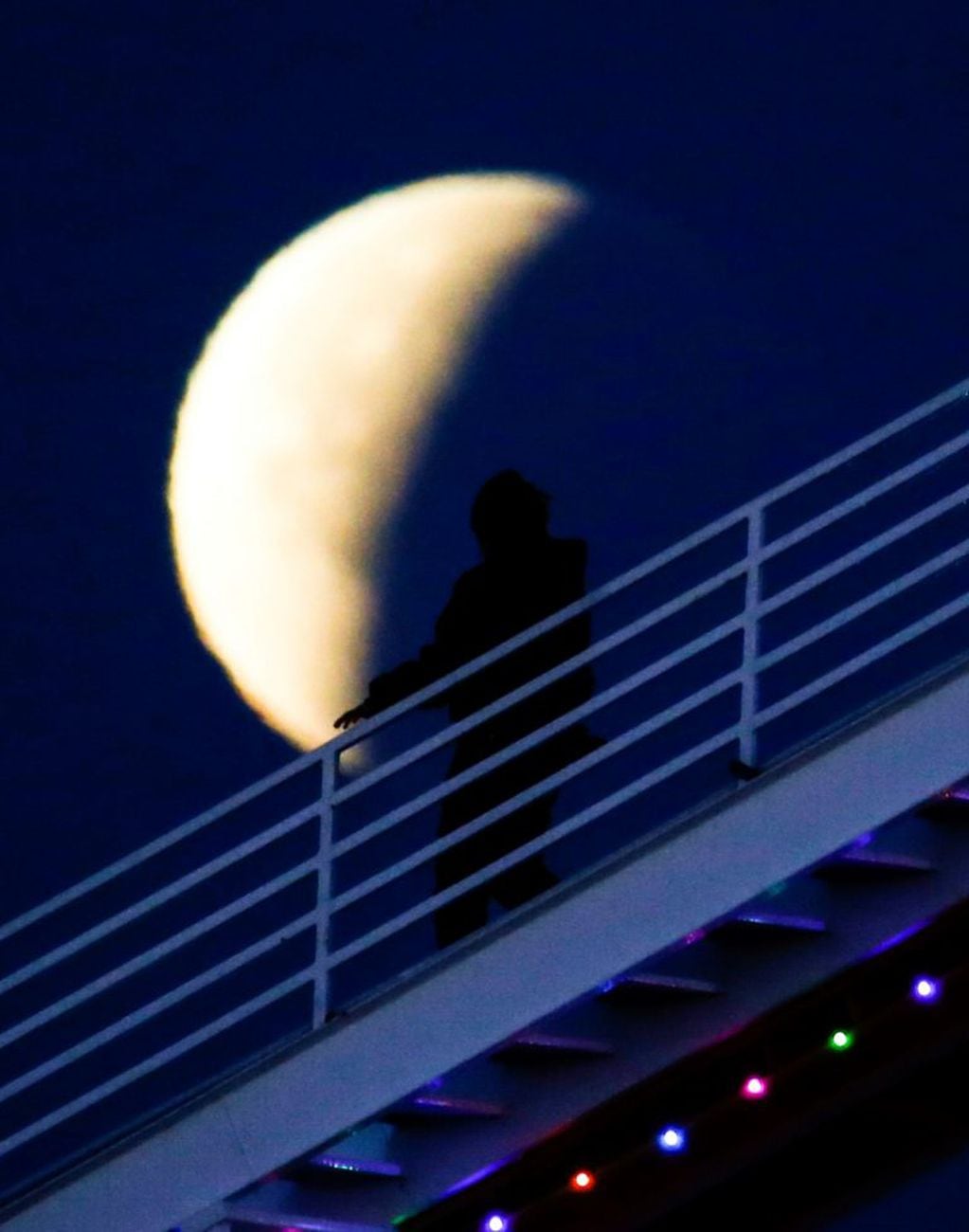 A worker of Pacific Park is silhouetted walks in front of a rare occurrence called a 'Super Blue Blood Moon' at Santa Monica Beach in Santa Monica, Calif., Wednesday, Jan. 31, 2018.   It's the first time in 35 years a blue moon has synced up with a supermoon and a total lunar eclipse, or blood moon because of its red hue. Hawaii and Alaska had the best seats, along with the Canadian Yukon, Australia and Asia. The western U.S. also had good viewing, along with Russia.  (AP Photo/Ringo H.W. Chiu)