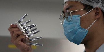 Empleado de SinoVac, en Pekín, manipula la vacuna contra el Covid-19