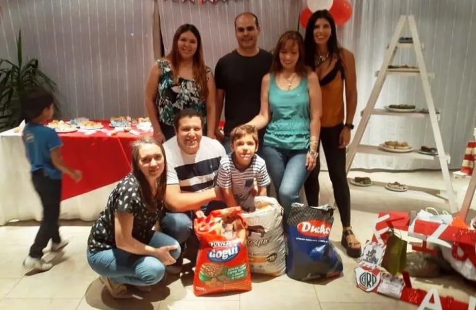 Valentino en su cumpleaños junto a su familia y el alimento destinado al refugio de animales.
