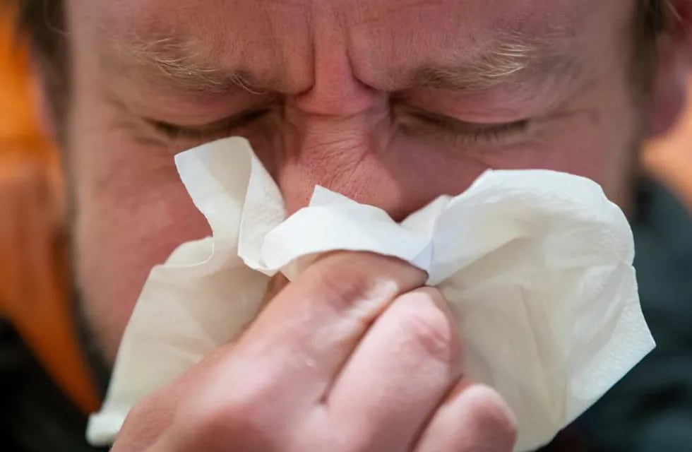 11 March 2020, England, London: A man blows his nose into a tissue. England's deputy chief medical officer Dr Jenny Harries has said that \