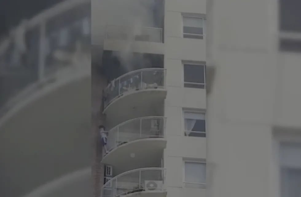El nene colgado en la parte de afuera del balcón, para tratar de huir de las llamas del departamento.