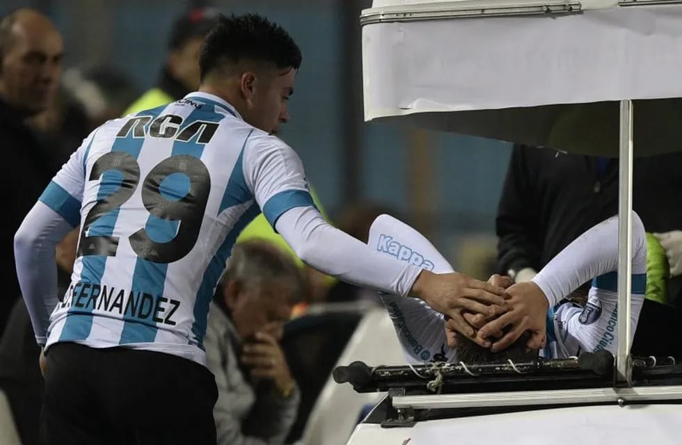 Argentina's Racing Club forward Brian Fernandez (L) comforts injured teammate forward Lautaro Martinez during the Copa Sudamericana first stage second leg football match against Colombia's Deportivo Independiente Medellin at Juan Domingo Peron stadium in Buenos Aires, Argentina, on June 29, 2017. / AFP PHOTO / JUAN MABROMATA