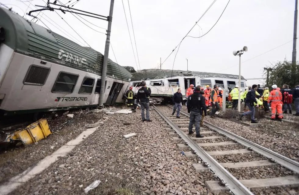 Miembros de los servicios de emergencia trabajan en el lugar del suceso después de que un tren descarrilara cerca de Milán
