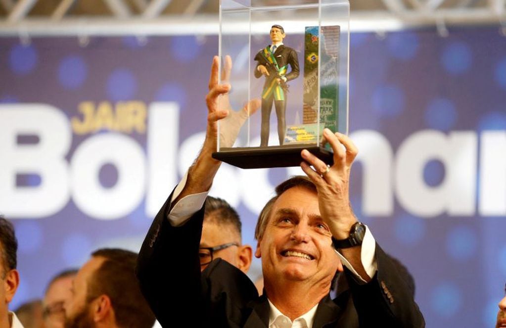 El candidato Jair Bolsonaro mostrando una figura de si mismo en una carrera en Curitiba, Brazil. (REUTERS)
