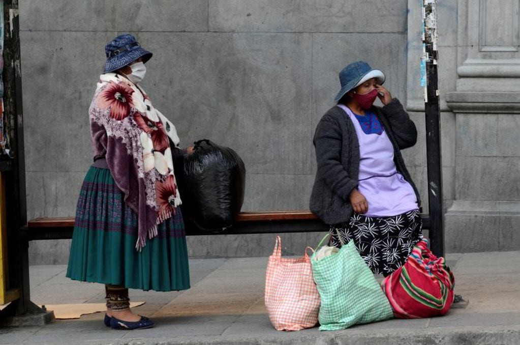 Dos mujeres esperan el colectivo en La Paz con tapaboca (Foto: Alexis-Demarco/ABI/dpa)