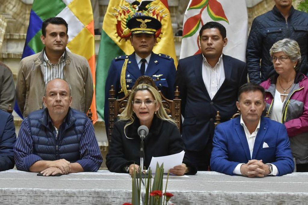 La presidenta interina de Bolivia, Jeanine Áñez (c), pronuncia un discurso este sábado rodeada de miembros de su gabinete, en el palacio de Gobierno en La Paz (Bolivia). Áñez advirtió de que no promulgará una ley como la que propone el partido de Evo Morales para darle inmunidad a él y al resto de autoridades que nombró durante su Presidencia. (Foto: EFE/Stringer)