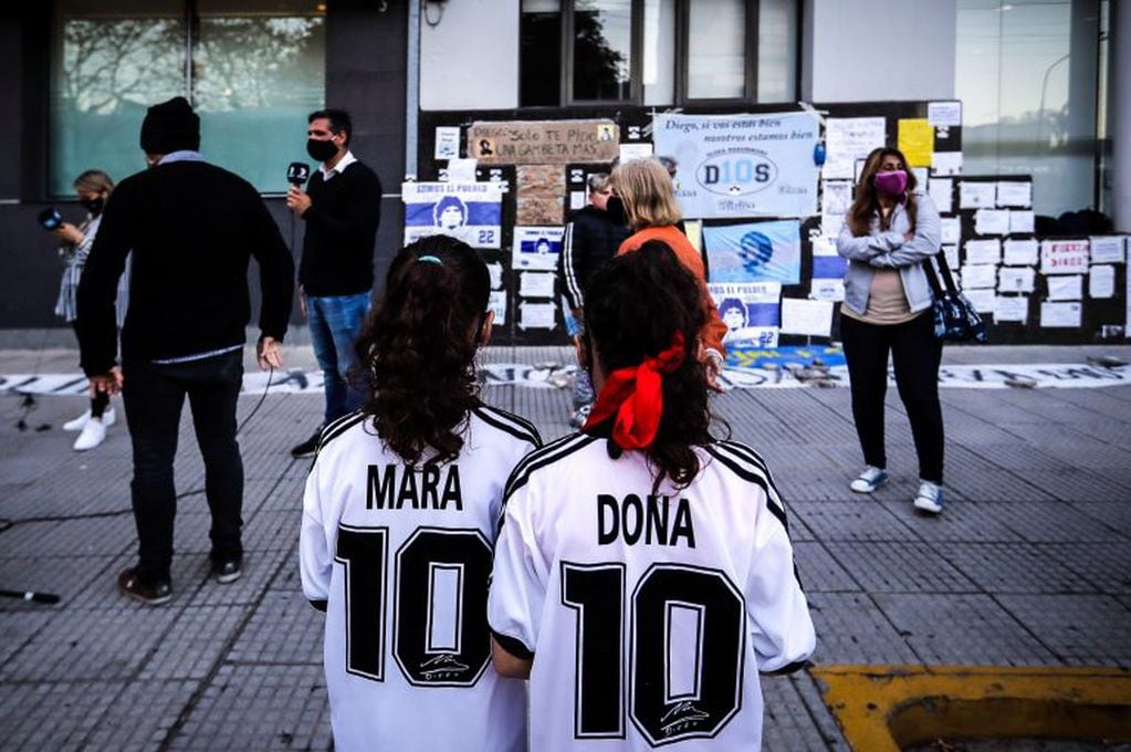 Las mellizas Mara y Dona esperan junto a otros fanáticos fuera de la clínica Olivos donde está internado Diego Maradona (EFE/ JUAN IGNACIO RONCORONI)