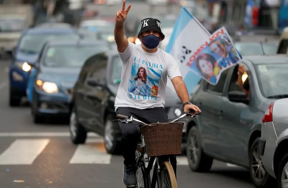 A man wearing a t-shirt depicting Argentine Vice President Cristina Fernandez de Kirchner rides his bike as he flashes the victory sign during a demonstration in support of Alberto Fernandez's administration on Loyalty Day, in commemoration of the 75th anniversary of the birth of Peronism, in Buenos Aires, Argentina October 17, 2020. REUTERS/Agustin Marcarian