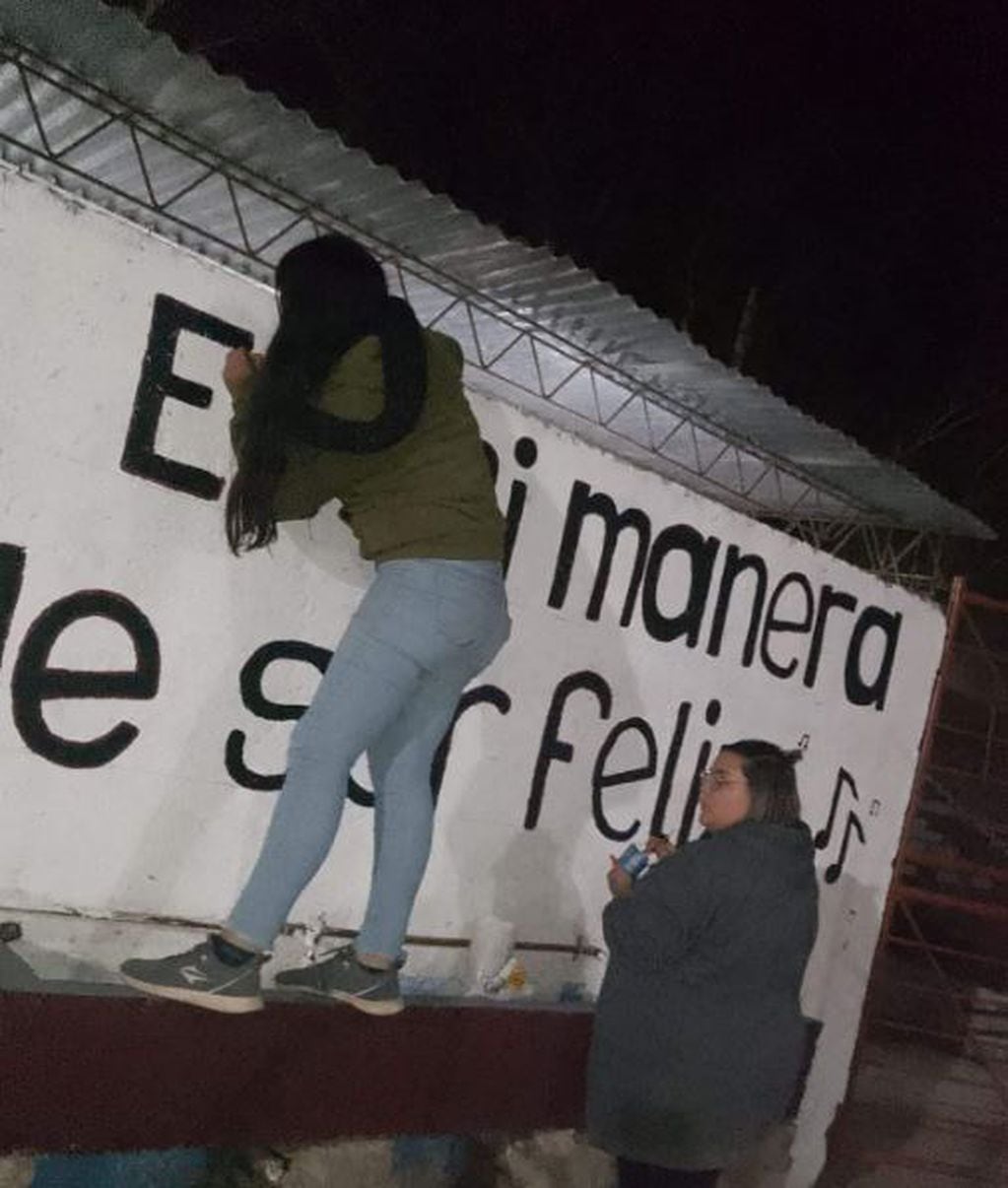 Las hinchada femenina de Luján Sport Club pintando el mural en el ingreso a la popular.