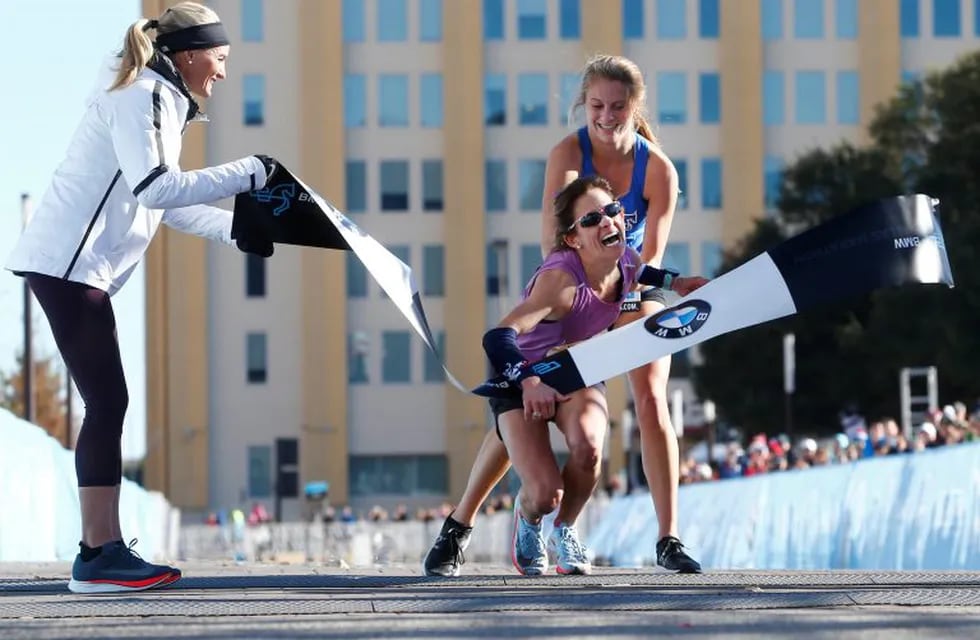Ariana Luterman ayuda a Chandler Self para llegar a la meta de la maratón de Dallas. (Nathan Hunsinger/The Dallas Morning News via AP)