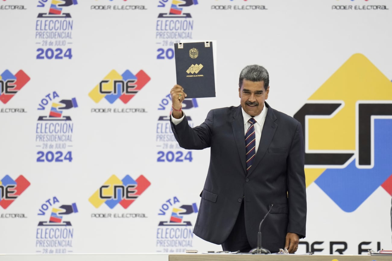 Nicolás Maduro sostiene su certificación del Consejo Nacional Electoral (CNE) que lo declara ganador de las elecciones presidenciales, en el CNE en Caracas, Venezuela, el lunes 29 de julio de 2024. (AP / Matías Delacroix)