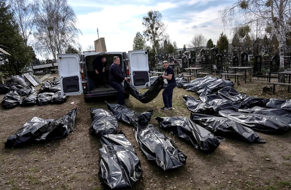 Trabajadores del cementerio descargan los cuerpos de los civiles asesinados desde una camioneta en el cementerio de Bucha, en las afueras de Kiev.