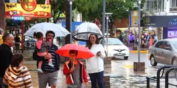 LLUVIA EN CARLOS PAZ. Durante el domingo los turistas visitaron el centro de Carlos Paz buscando refugio de la lluvia. (La Voz)
