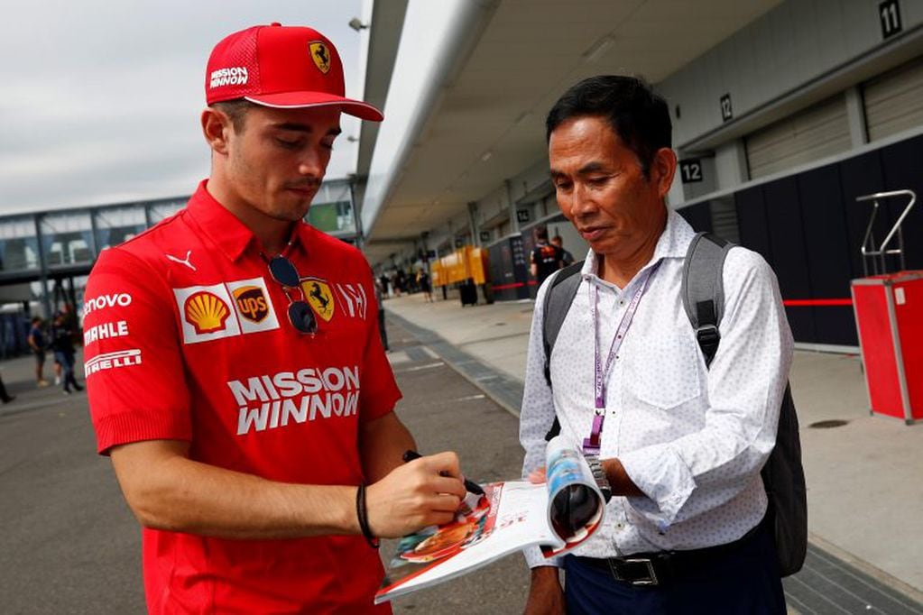 Charles Leclerc (L), piloto de la escudería Ferrari, firma un autógrafo en el circuito de Suzuka. EFE/EPA/DIEGO AZUBEL