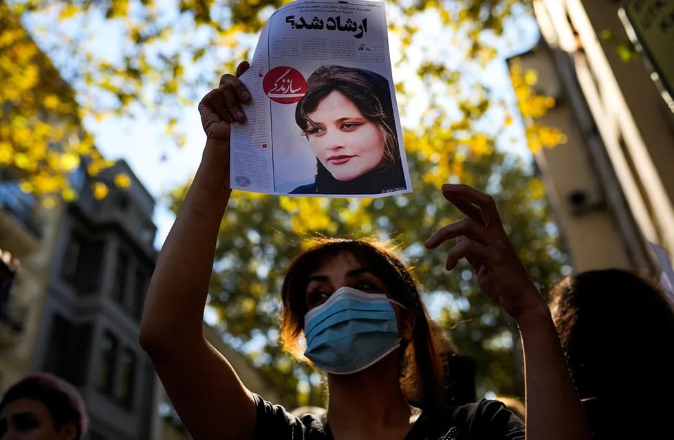 Una mujer sostiene una copia de un artículo de periódico con la foto del iraní Mahsa Amini que dice en persa: "¿Era Ershad?" durante una protesta contra la muerte de Amini, frente al consulado general de Irán en Estambul, Turquía. (AP)