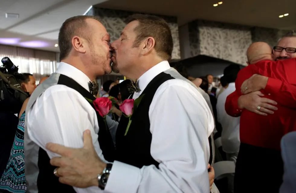Vaughn Brison, 51, left, and Steve Visano, 54, right, kiss after exchanging their vows during a group wedding ceremony at a hotel in honor of Florida's ruling in favor of same-sex marriage equality, Thursday, Feb. 5, 2015, in Fort Lauderdale, Fla. In January Florida became the 36th state where gay marriage in legal. (AP Photo/Lynne Sladky) fort lauderdale florida eeuu Vaughn Brison Steve Visano ceremonia colectiva boda homosexual parejas del mismo sexo matrimonio boda masiva casamiento igualitario