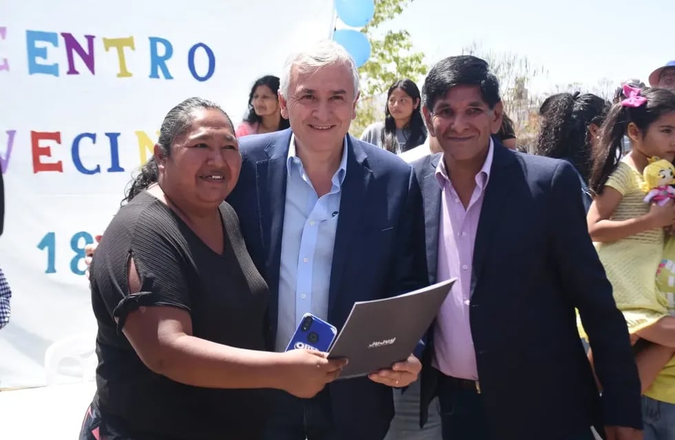 Una de las 600 familias beneficiarias de la entrega de lotes en Alto Comedero, recibiendo el decreto de manos del gobernador Gerardo Morales.