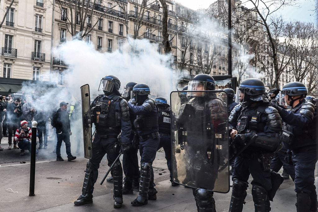 Las fuerzas policiales francesas intentan extinguir los fuegos artificiales lanzados por los manifestantes.