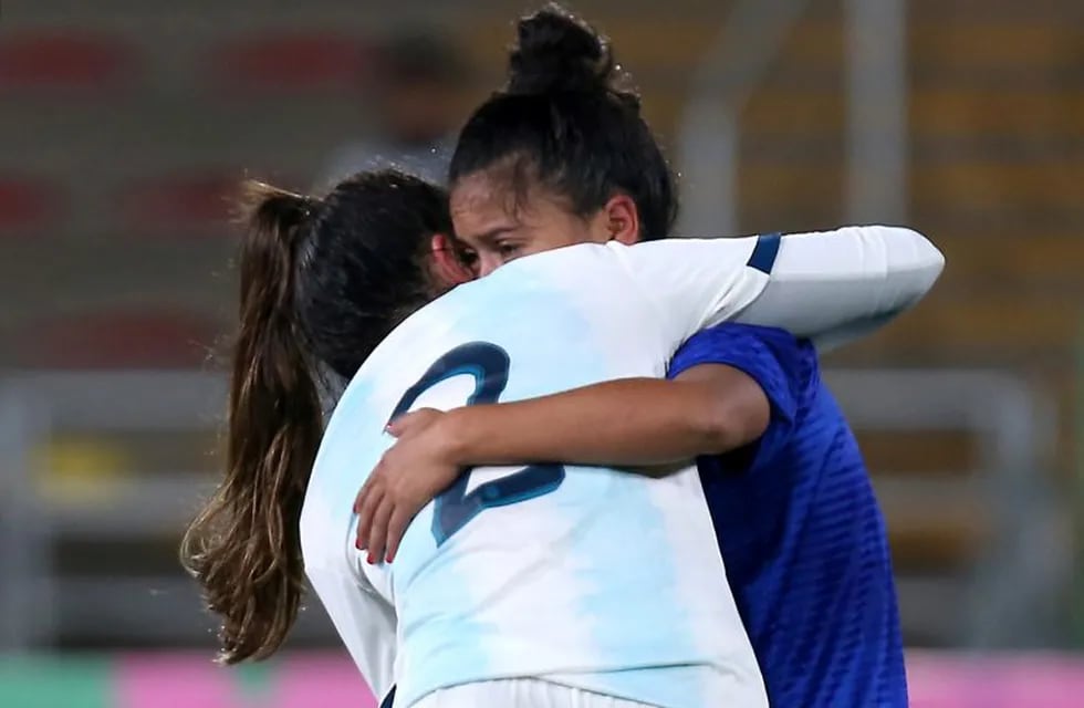 La defensora argentina Agustina Barroso consuela Damia Cortaza al termina la semifinal de fútbol en la que el Seleccionado Femenino de Fútbol derrotó a su par de Paraguay por los Juegos Panamericanos de Lima 2019. (Luka Gonzales / AFP)