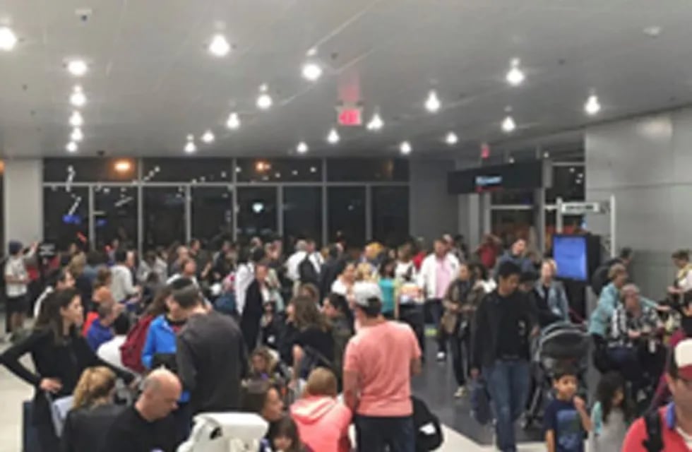 This photo provided by Shawn Woodward shows the scene from the Miami Airport, Thursday, Sept. 7, 2017. Police said they were investigating an officer-involved shooting Thursday night at the Miami airport that shut down a terminal as people looked to leave Florida ahead of Hurricane Irma. Police said in a statement that they were responding, but no other details were immediately available. (Shawn Woodward via AP)