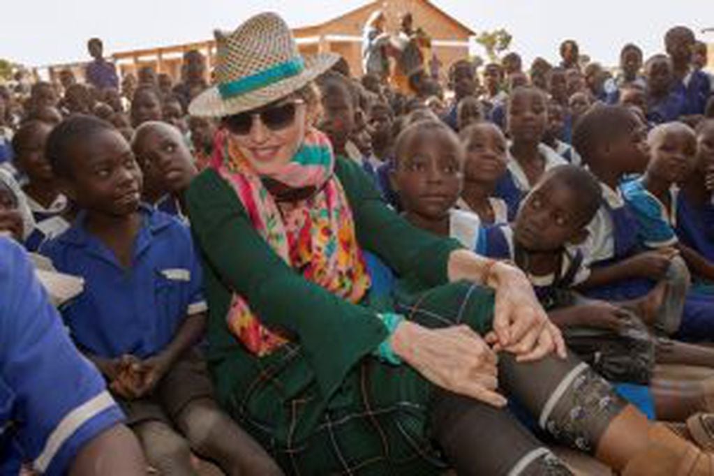 (FILES) This file photo taken on November 30, 2014 shows US pop superstar Madonna sitting among Malawian children during a visit to the Mkoko Primary School, one of the schools Madonna's Raising Malawi organization has built jointly with US organization B