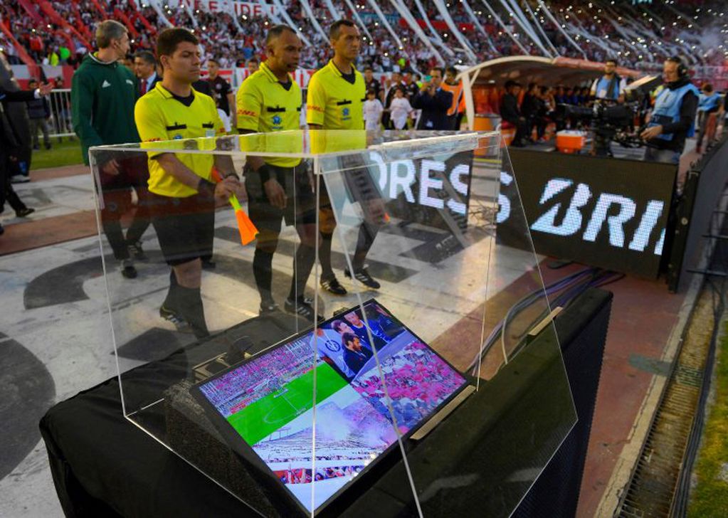 (FILES) In this file photo taken on October 25, 2017 Brazilian referee Wilton Pereira Sampaio (C) and his assistants pass by a screen of the Video Assistant Referee (VAR) before the start of the Copa Libertadores 2017 semifinal first leg football match between Argentina's River Plate and Lanus at the Monumental stadium in Buenos Aires.
The controversial Video Assistant Referee (VAR) system looks set to be used at the World Cup in Russia after international rules body IFAB gave it their backing on March 3, 2018.
"The International Football Association Board unanimously approved the use of video assistant referees at its 132nd Annual general meeting," IFAB said in a statement.
 / AFP PHOTO / Juan MABROMATA