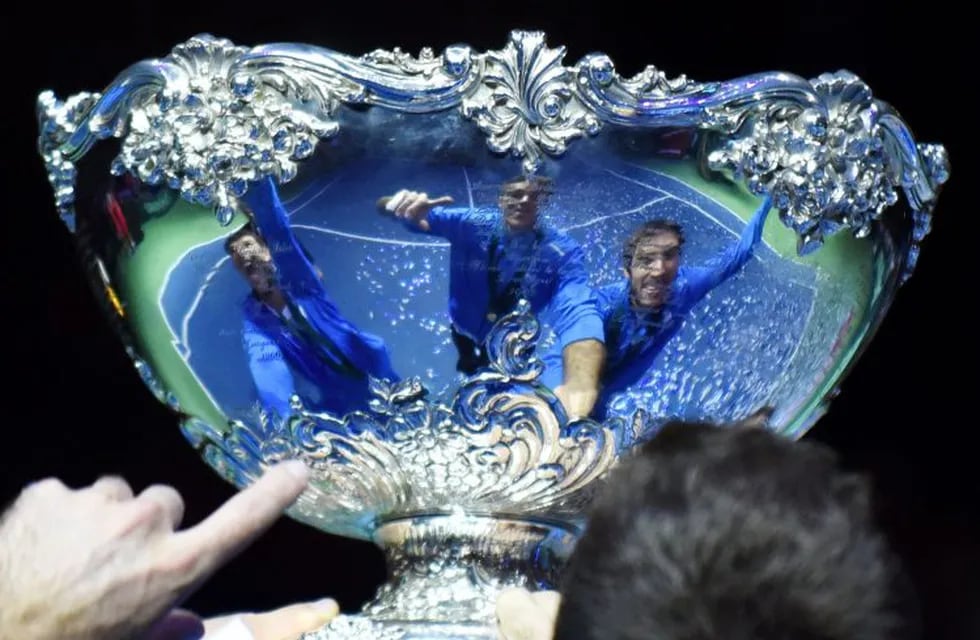 festejos de los tenistas argentinos con el trofeo ensaladera copa argentina campeon de copa davis \r\n\r\nA picture shows the reflections of Argetina's Federico Delbonis (L), Juan martin del Potro (C) and Leonardo Mayer on the trophy during celebrations after they won the Davis Cup World Group final between Croatia and Argentina at the Arena hall in Zagreb, on November 27, 2016.  / AFP PHOTO / - zagreb croacia Federico Delbonis juan martin del potro leonardo mayer campeonato torneo copa davis 2016 tenis partido final tenistas equipo croacia argentina