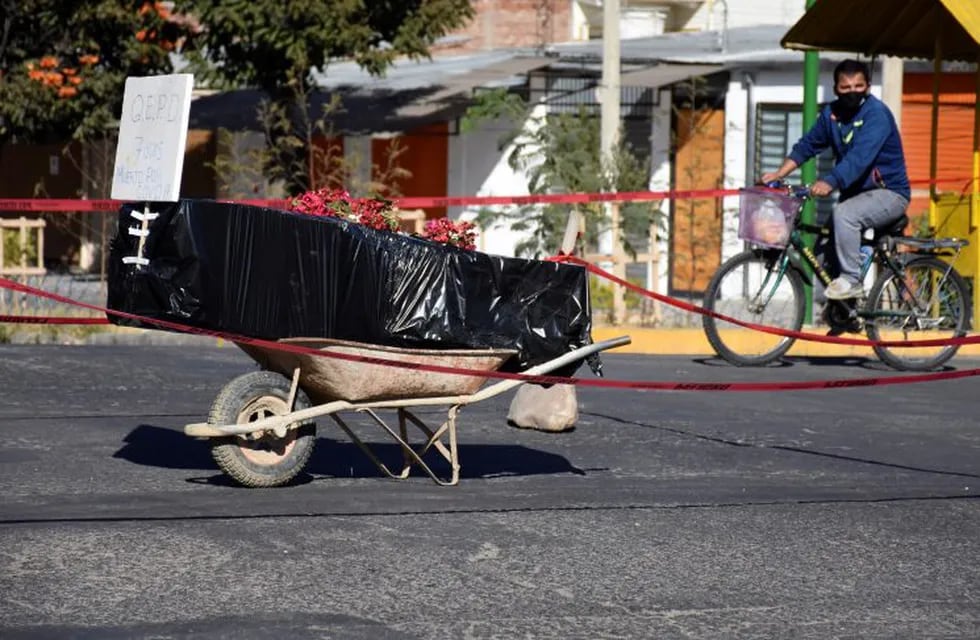 A coffin wrapped in plastic containing the remains of an unidentified men, who died last week, sits on a wheelbarrow in the middle of a street, placed there by his family to draw attention of the authorities to show that his remains are yet to be collected, in Cochabamba, Bolivia, Saturday, July 4, 2020. Funeral services in Cochabamba are overwhelmed and bodies are piling up, waiting for cremation or burial, as new coronavirus cases rapidly multiply in one of the epicenters of the pandemic in Bolivia. (AP Photo/Dico Soliz)